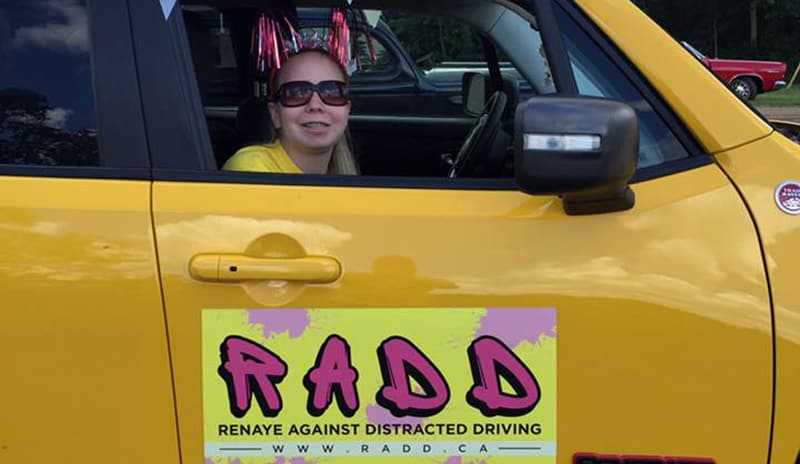 Renaye in a vehicle displaying the RADD logo.